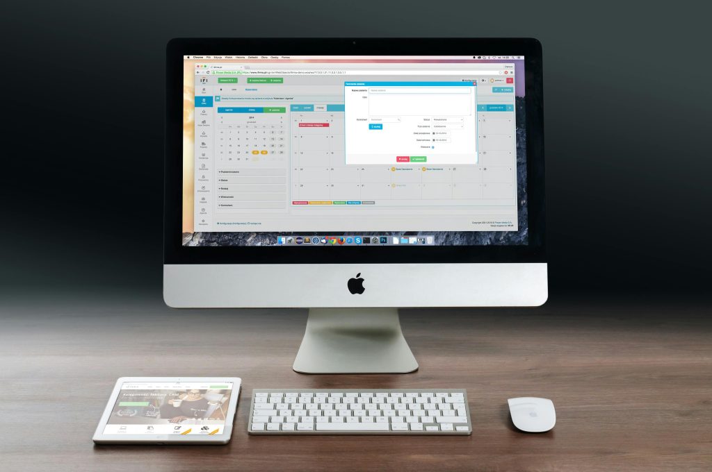 apple imac ipad workplace 38568 38568 A sleek office setup featuring an Apple iMac, iPad, and keyboard on a wooden desk.